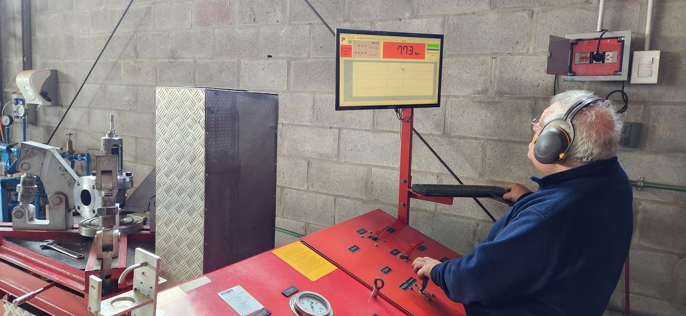 Técnico calibrando una válvula en el banco digital; la pantalla muestra 7,73 bar